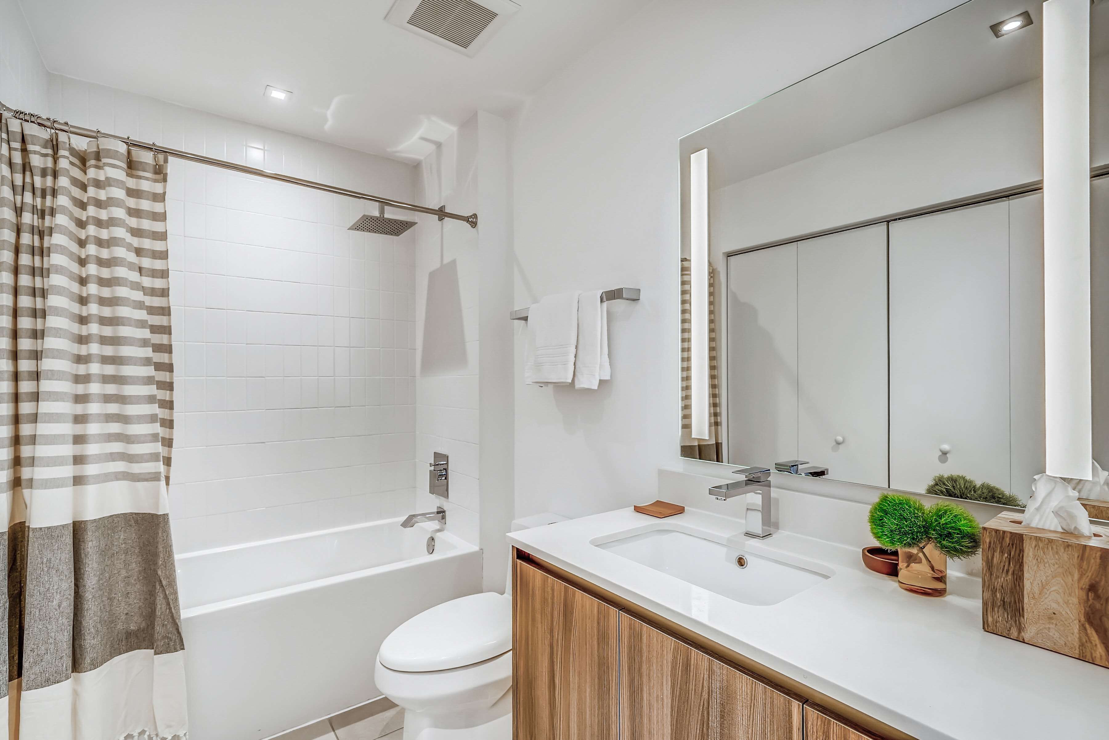 A modern bathroom with a bathtub, toilet, and sink.