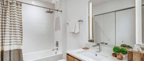A modern bathroom with a bathtub, toilet, and sink.