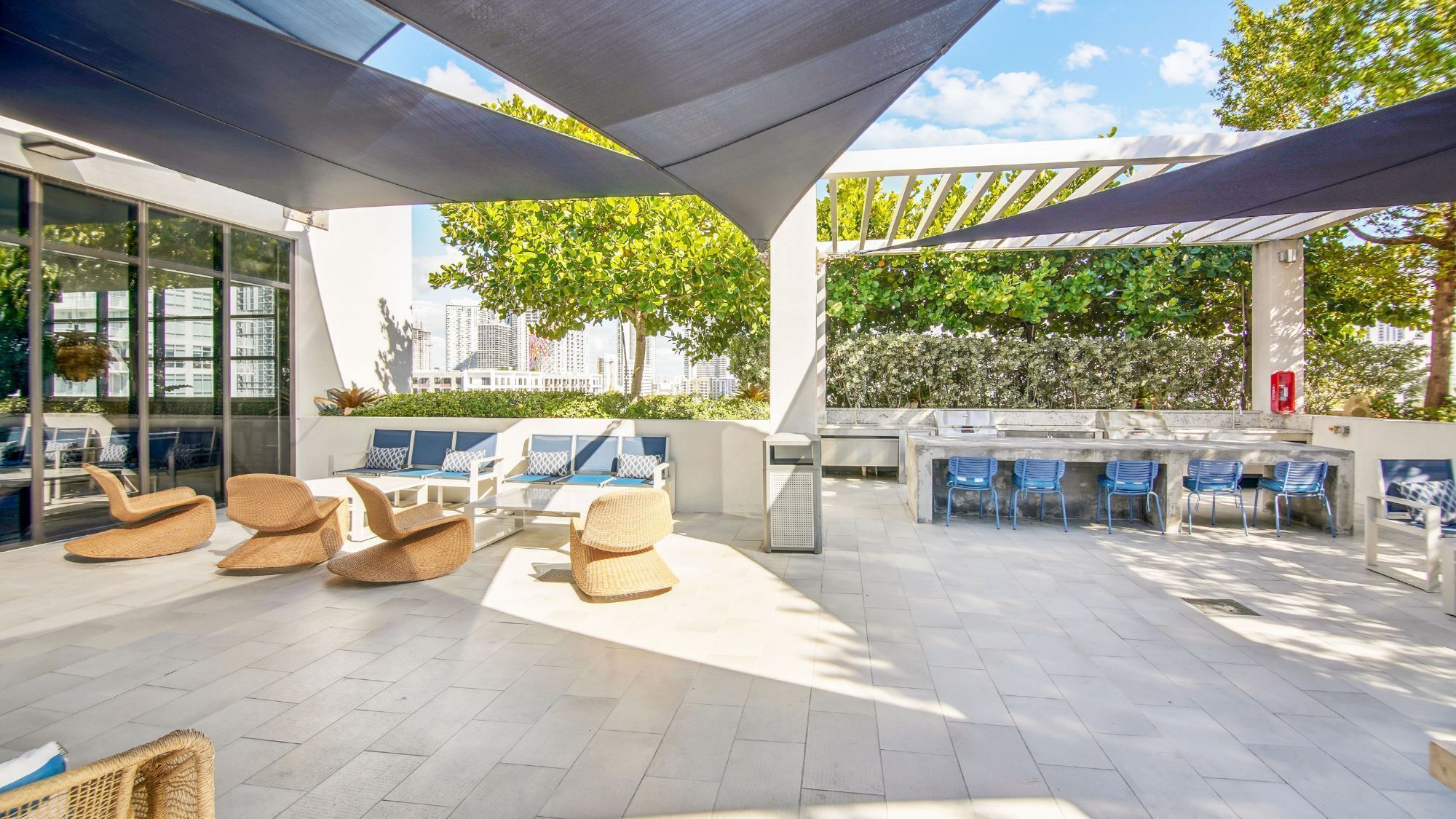 An outdoor seating area with wicker chairs and a bar.