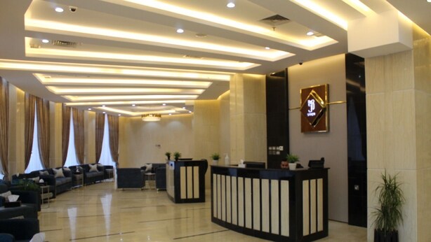 A modern hotel lobby with a reception desk, seating area, and a large mirror. - The 58 Hotel Mahboula (Mahboula)