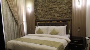 A hotel room with a large bed, a headboard, a nightstand, and a wardrobe. - The 58 Hotel Mahboula (Mahboula)