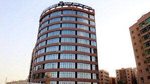 A multi-story hotel with a curved facade, large windows, and a sign indicating it is a hotel. - The 58 Hotel Mahboula (Mahboula)