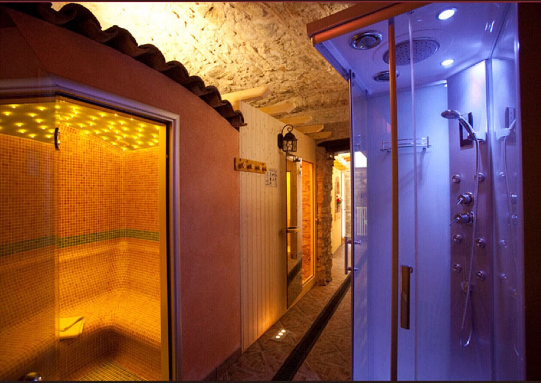 Ein Hotelbad mit Dusche, gefliesten Wänden und einer Tür mit Griff.
