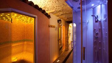 Ein Hotelbad mit Dusche, gefliesten Wänden und einer Tür mit Griff.