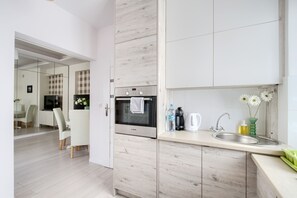 Comfort appartement | Privékitchenette | Een koelkast met diepvriezer, een microgolfoven, een oven, een kookplaat