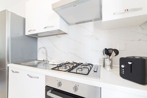 A kitchen with a gas stove, a sink, a toaster, and a refrigerator. - A delightful split level apartment with a beautiful terrace with view on the hills. (Firenze)