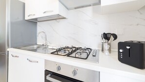 A kitchen with a stainless steel refrigerator, a gas stove, a toaster, and a marble countertop. - A delightful split level apartment with a beautiful terrace with view on the hills. (Firenze)
