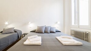A hotel room with a bed, two bedside tables, and a window. - A delightful split level apartment with a beautiful terrace with view on the hills. (Firenze)