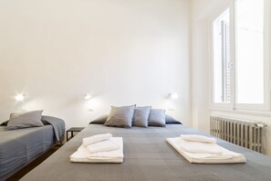 A hotel room with a bed, two bedside tables, and a window. - A delightful split level apartment with a beautiful terrace with view on the hills. (Firenze)