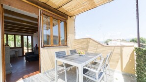 An outdoor patio with a table and chairs, a view of the surrounding area, and a building entrance. - A delightful split level apartment with a beautiful terrace with view on the hills. (Firenze)