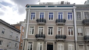 A multi-story building with patterned exterior walls, multiple balconies, and a black door. - ALEXANDER APARTMENTS. LISBON (Lisboa)