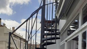 A black spiral staircase with a metal railing, leading to an upper floor. - ALEXANDER APARTMENTS. LISBON (Lisboa)