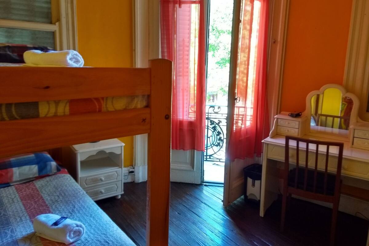 A child's bedroom with a bunk bed, a small desk, and a chair.
