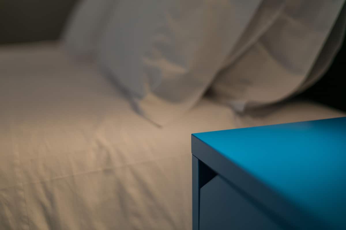A bed with a blue object on it, possibly a piece of furniture or equipment.