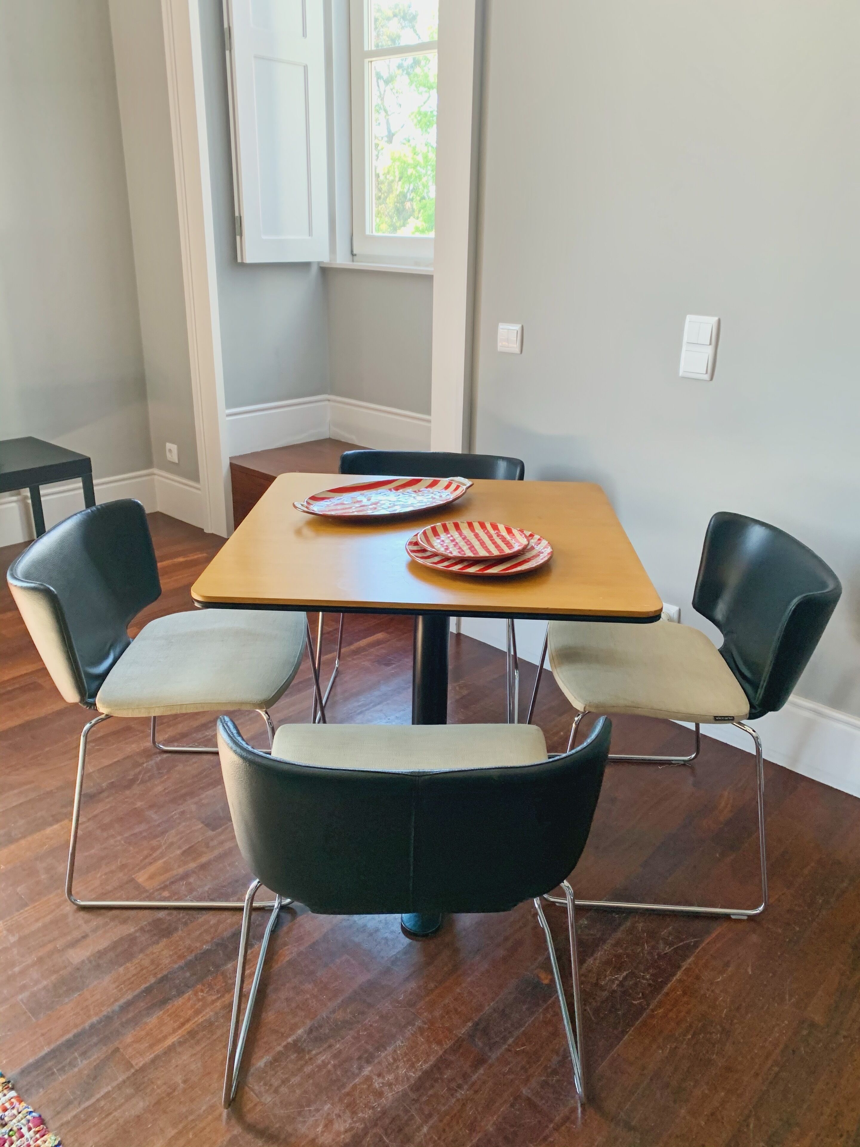 Un coin repas comprenant une table en bois et quatre chaises, dont deux sont dotées d’assises rembourrées et deux ont des structures en métal.