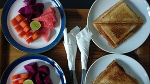 Two plates of fruit and two plates of toasted bread. - Bale Delod Guest House (Ubud)