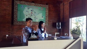 A reception desk with a map and a speaker in the background. - Majapahit Homestay by Bhagaskara (Bejijong)