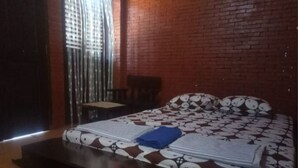 A room with a bed, a chair, and a window with blinds. - Majapahit Homestay by Bhagaskara (Bejijong)