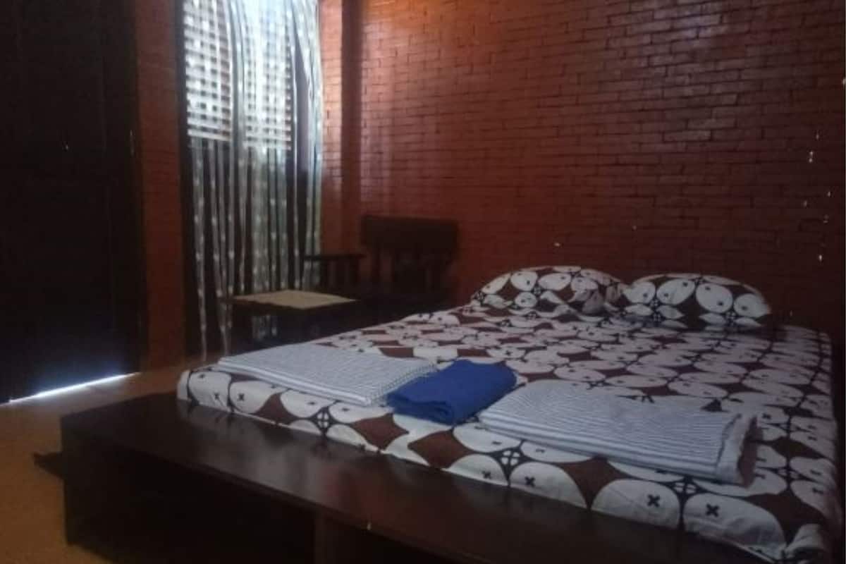 Een kamer met een bed, een stoel en een raam met jaloezieën.