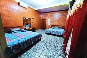 Una habitación de hotel con dos camas, una pared de madera, piso de baldosas y un espejo.