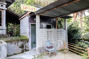 A small, rustic building with a sign reading "TOILET" above the entrance. - Serut 1 Homestay - Hostel (Kulon Progo)