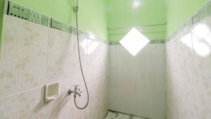 A small, enclosed shower area with a handheld showerhead, a towel rack, and a small shelf. - Serut 2 Homestay - Hostel (Kulon Progo)
