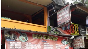 Een restaurant met een opvallend bord waarop verschillende gerechten staan vermeld.