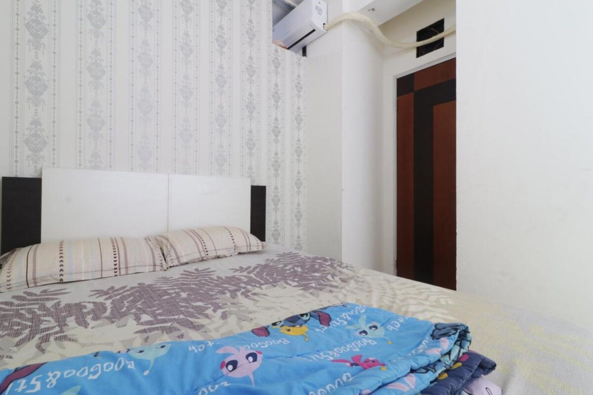 Une chambre à coucher avec un lit, des rideaux à motifs et une porte en bois.