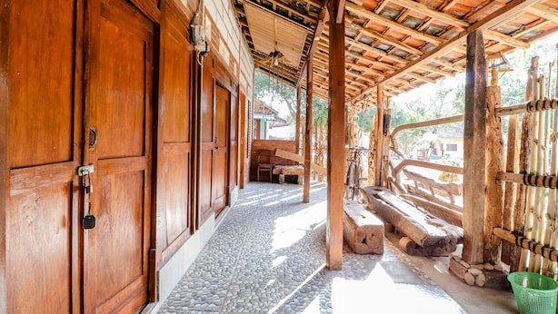 A traditional wooden building with a tiled floor and a covered walkway. - Penginapan Joko Samudro (Wonosari)