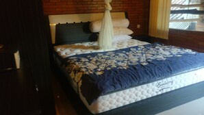 Un letto a baldacchino, con copripiumino floreale e testata a muro in mattoni.