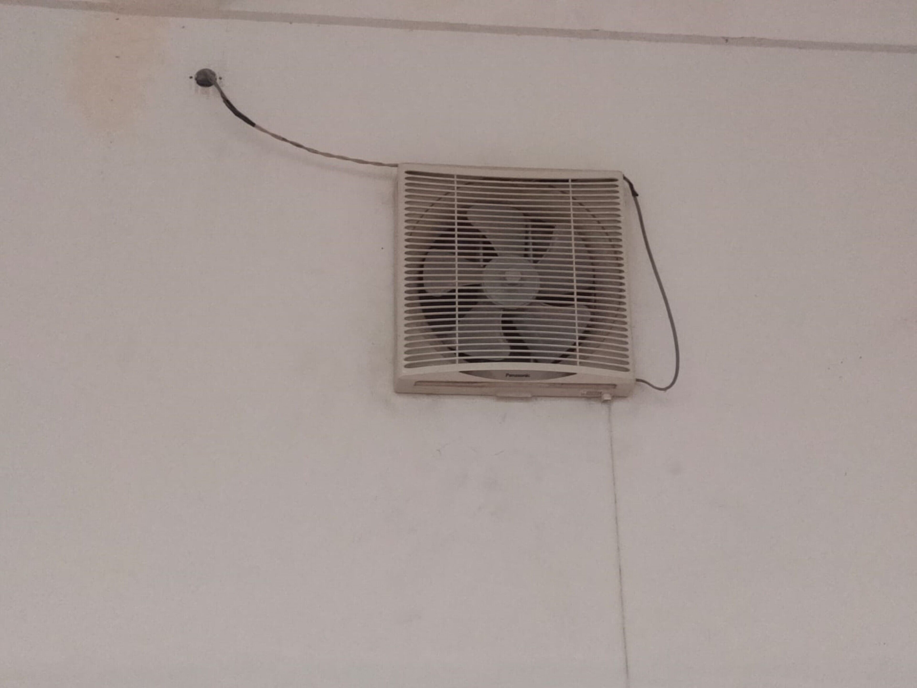 Un aire acondicionado instalado en la pared, con cable de alimentación visible.