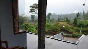 Una habitación con un ventanal grande que da a un paisaje verde.