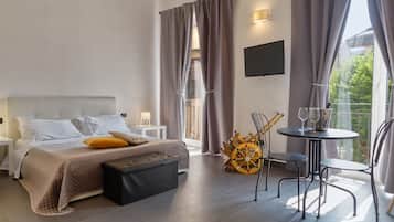 Una camera d'albergo moderna con un letto, comodini, un tavolino con bicchieri e una sedia.