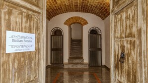 A hallway with a sign for Sicilian Rooms in Palermo, featuring a brick ceiling, arched doorways, and a marble floor. - Sicilian Rooms Palermo (Palermo)