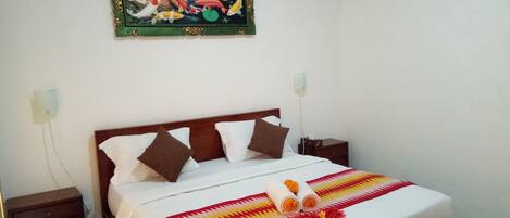 A neatly made bed with a patterned bedspread, two pillows, and a decorative item on the bed.