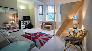 Un salon moderne avec un canapé, une table basse et un coin repas.