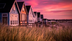 A row of beach houses with a view of the sea and a sunset sky. - The Breaking Surf (Poole)