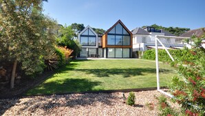 A modern house with a well-maintained lawn and a fenced yard. - Spyglass (Poole)