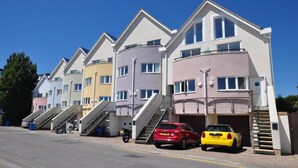 Una hilera de edificios residenciales de varios pisos con escaleras externas que dan al primer nivel.