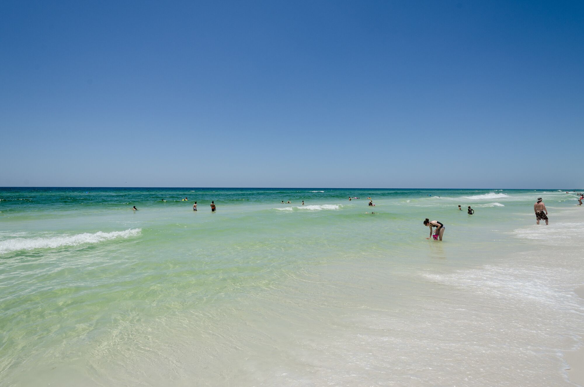 A beach with clear turquoise water and a sandy shore.