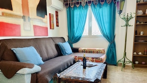 Una sala de estar con un sofá, una mesa de centro y una estantería.