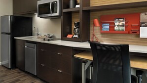 A modern kitchen with a microwave, coffee maker, and a red sign on the wall. - TownePlace Suites by Marriott Memphis Olive Branch (Olive Branch)