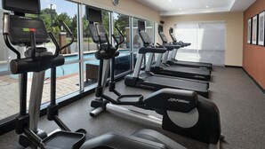 A gym with treadmills, ellipticals, and a pool view. - TownePlace Suites by Marriott Memphis Olive Branch (Olive Branch)
