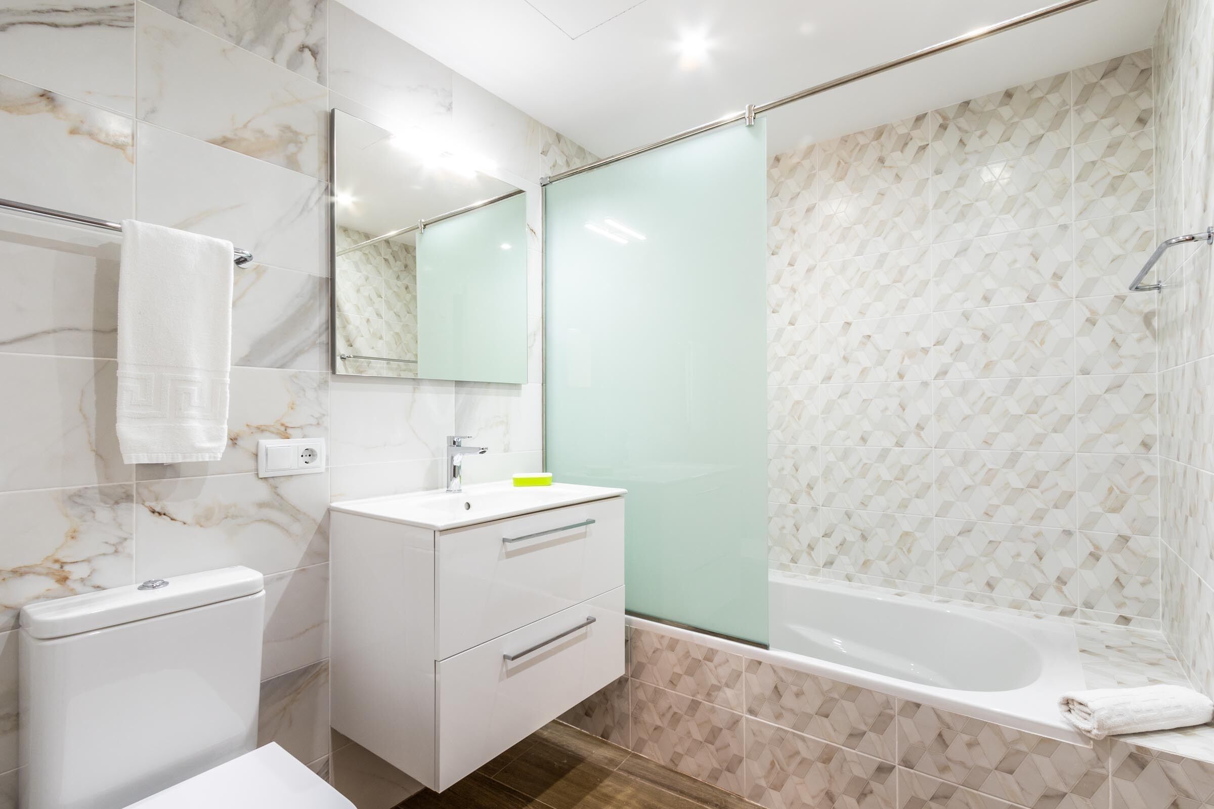 A modern bathroom with a toilet, sink, and bathtub.
