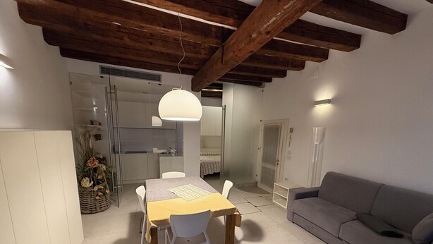 Ein modernes Interieur mit Essbereich, einer Couch und einer Küche.