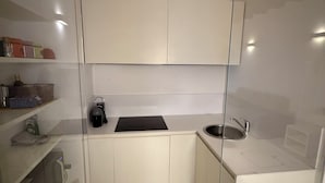 Eine moderne Küche mit weißen Schränken, einer schwarzen Arbeitsplatte und einer Edelstahlspüle.