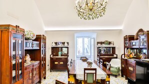 A dining area with a wooden table, chairs, and a chandelier. - Della Monica Rooms (Vietri sul Mare)