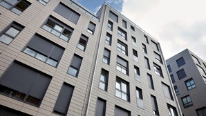 A multi-story building with a modern architectural design, featuring a series of windows and balconies. - Muinoa 1 by FeelFreeRentals (Donostia)