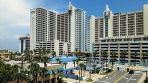 A high-rise hotel with multiple floors, a parking garage, and a view of the ocean.