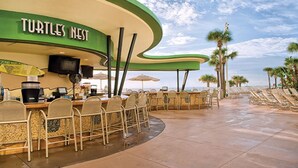 A beachside restaurant named "Turtles Nest" with outdoor seating and umbrellas.